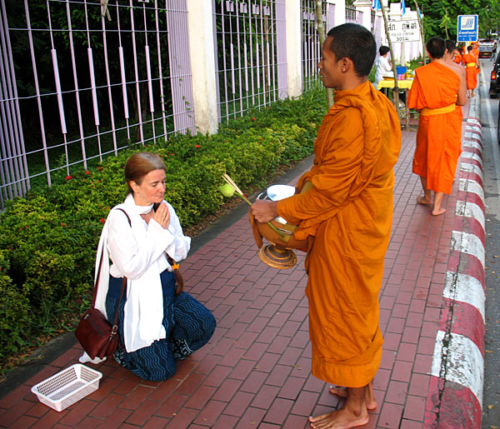 Monk praying for Tara after she offered him food in Chiang Mai