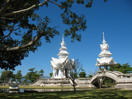 Wat Rong Khun, perhaps better known to foreigners as the White Temple, is a privately owned art exhibit in the style of a Buddhist temple in Chiang Rai Province, Thailand. It is owned by Chalermchai Kositpipat, who designed, constructed, and opened it to visitors in 1997.