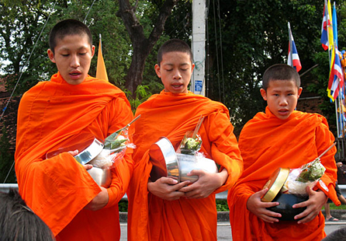 Three young monks begging for food in Chiang Mai