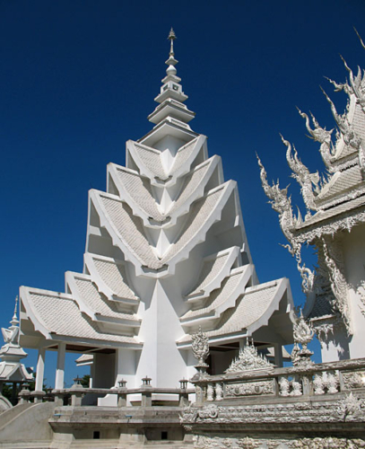 Wat Rong Khun, perhaps better known to foreigners as the White Temple, is a privately owned art exhibit in the style of a Buddhist temple in Chiang Rai Province, Thailand. It is owned by Chalermchai Kositpipat, who designed, constructed, and opened it to visitors in 1997.