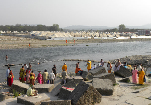 River scene in Haridwar with large camp grounds across the river.