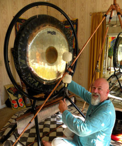 Ganga banging a gong at Erik and Scott's house in Mt. Shasta